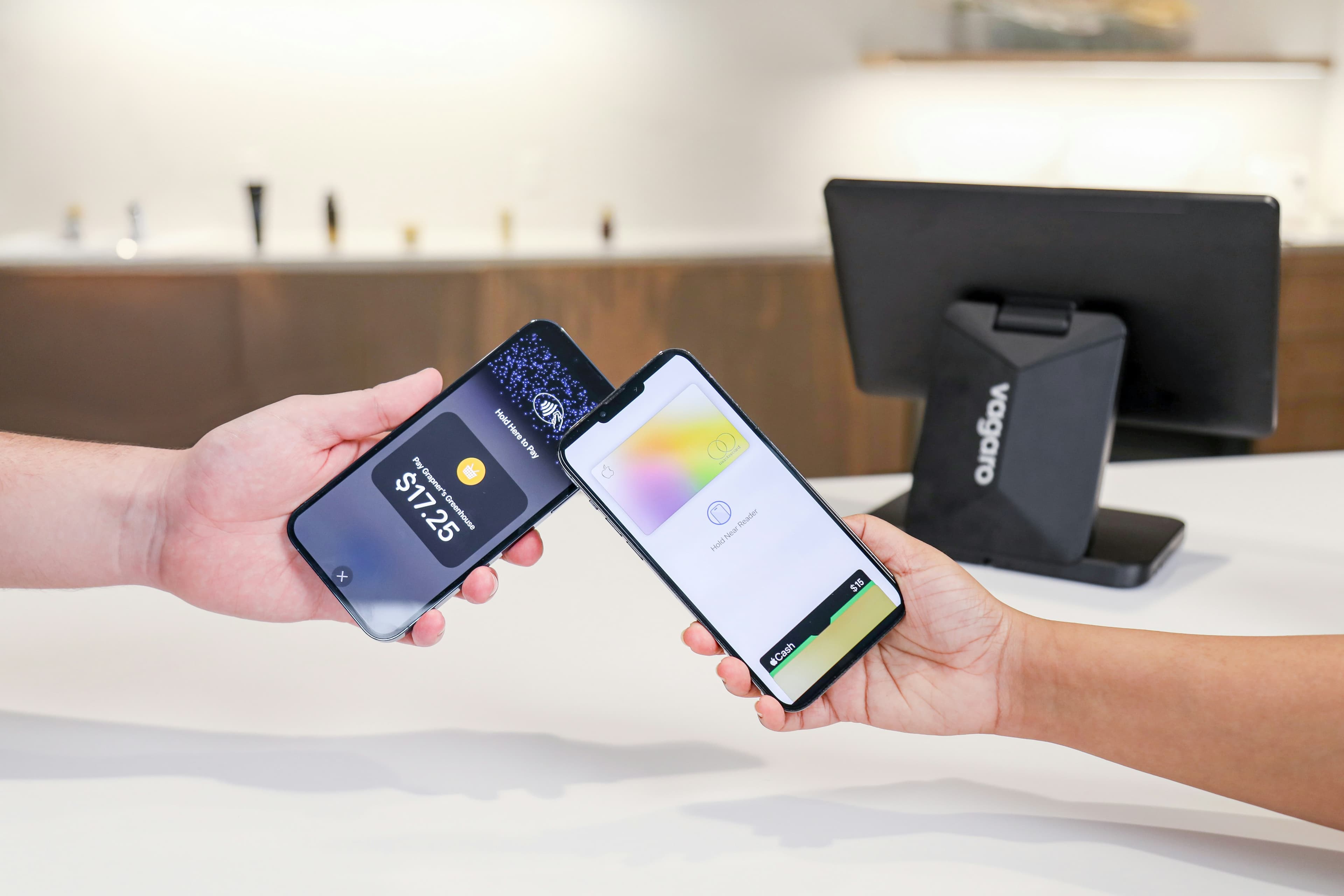 Two people holding phones together to make a contactless payment
